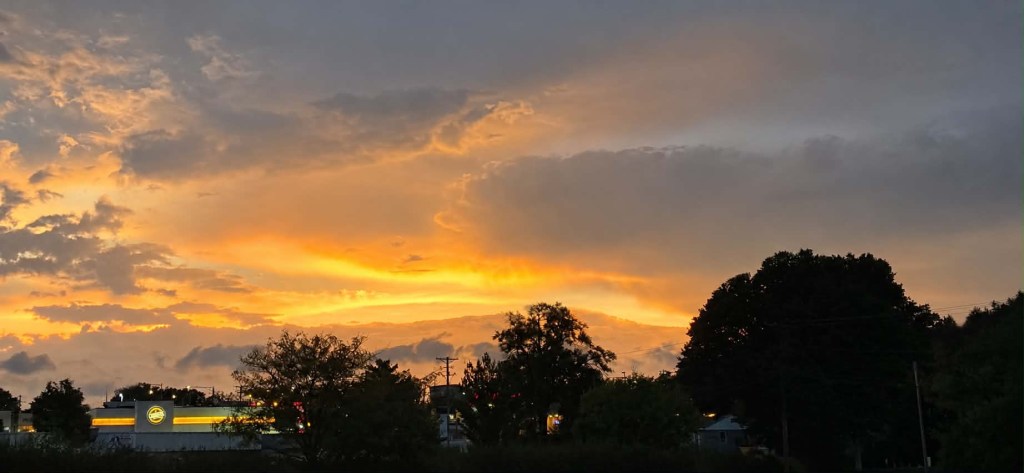 Golden sunset beneath layered evening clouds in Raytown, Missouri, photographed by my husband on September 15, 2026