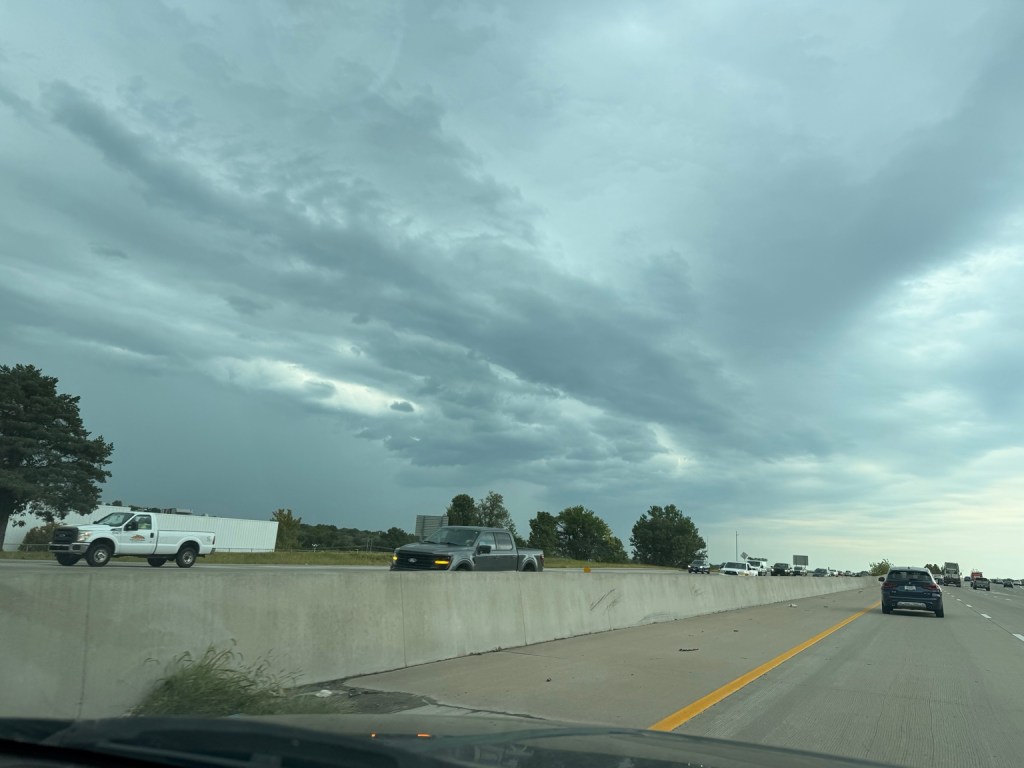 Dark layered storm clouds and rain over the highway in Kansas City, Missouri at 2:44 PM on September 9, 2026.