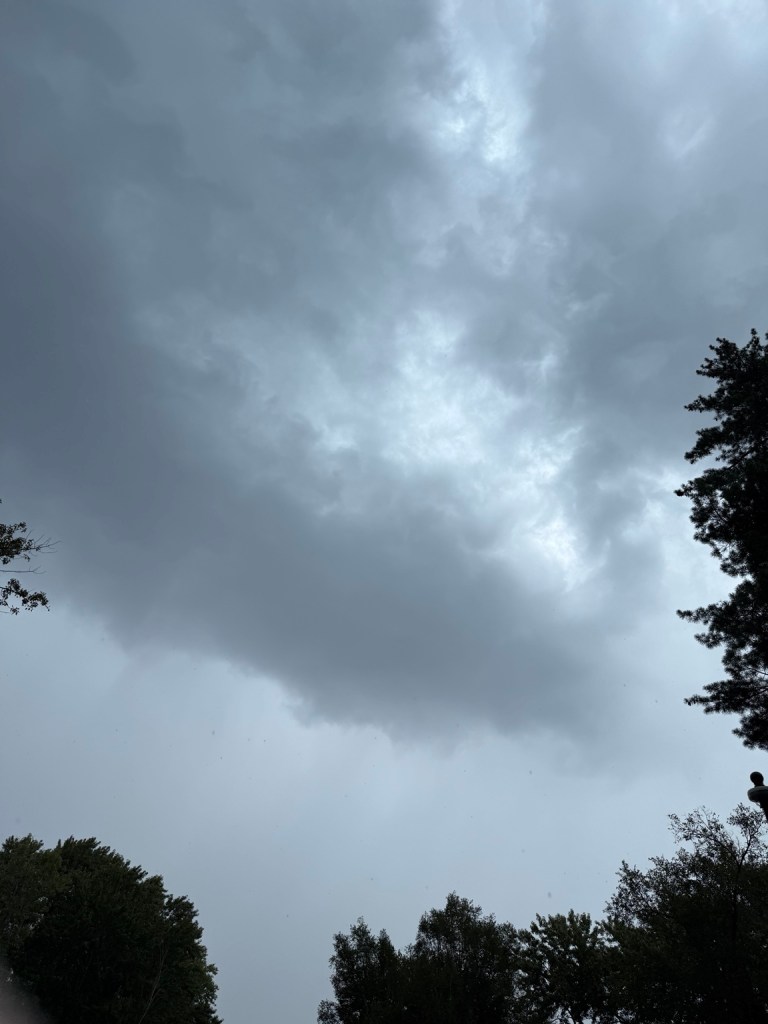 Dark storm ceiling overhead in Raytown, Missouri at 2:57 PM on September 9, 2026, with a pale opening filtering daylight.