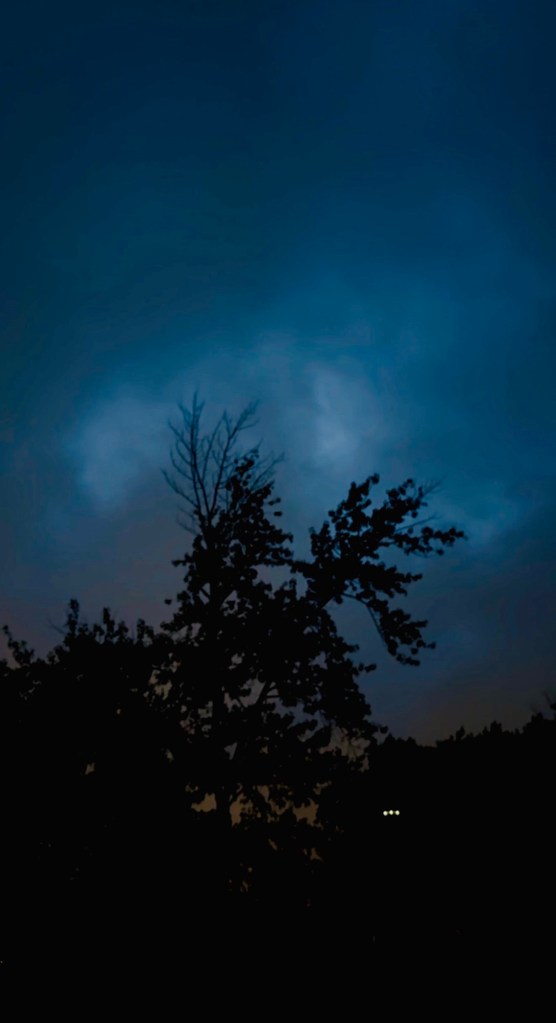 Deep blue pre-dawn sky over silhouetted trees in Raytown, Missouri at 6:45 AM on September 10, 2026.