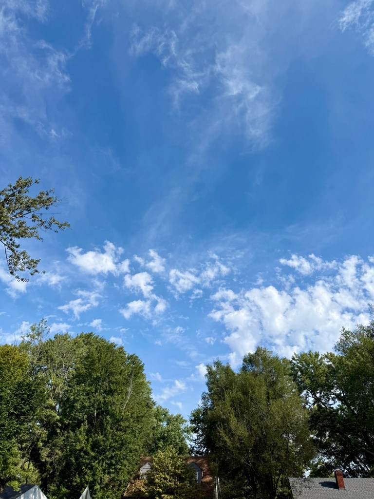 Blue September sky with wispy high clouds and scattered lower clouds over Raytown