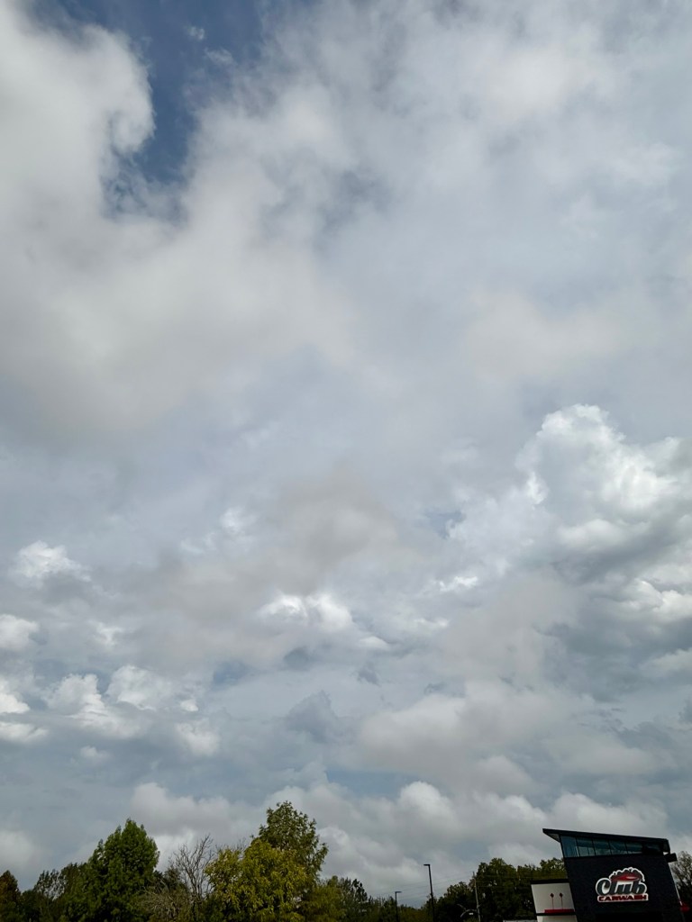 A textured gray and white cloud field over Independence, with a small patch of blue and brighter billowing clouds.