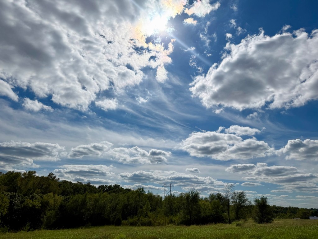 Layered clouds, blue sky and bright afternoon sun over Kansas City, Missouri