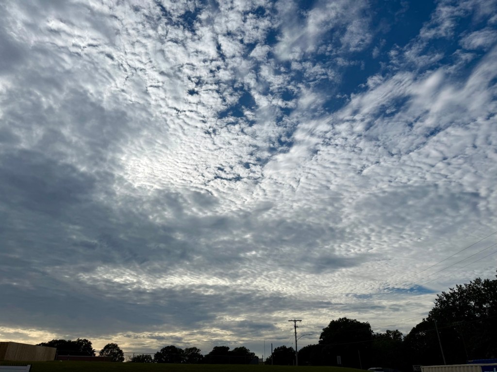 Layered rippled clouds with blue openings and filtered late-afternoon sunlight over Raytown.