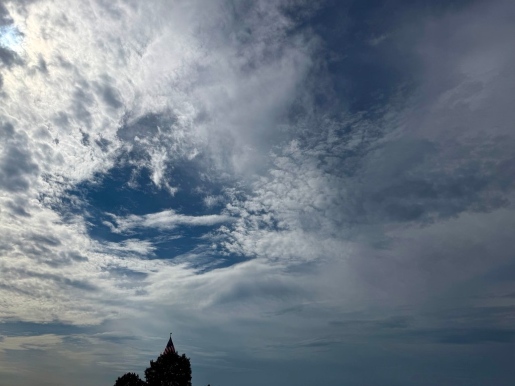 Blue opening surrounded by rippled, wispy, and heavier gray cloud layers over Independence, Missouri