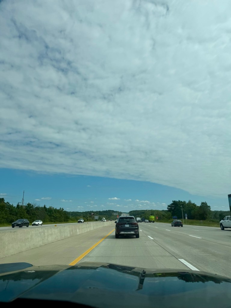 Broad cloud deck ending above a band of blue sky along the highway on the Missouri side