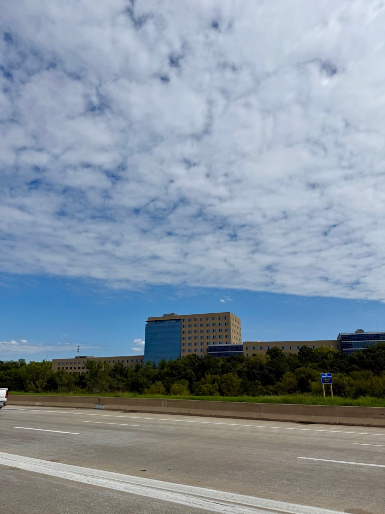 Textured cloud deck with a sharp lower edge opening to blue sky over Missouri
