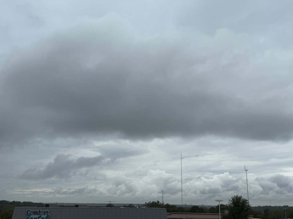 Layered gray cloud deck with brighter billowing clouds on the horizon in Raytown