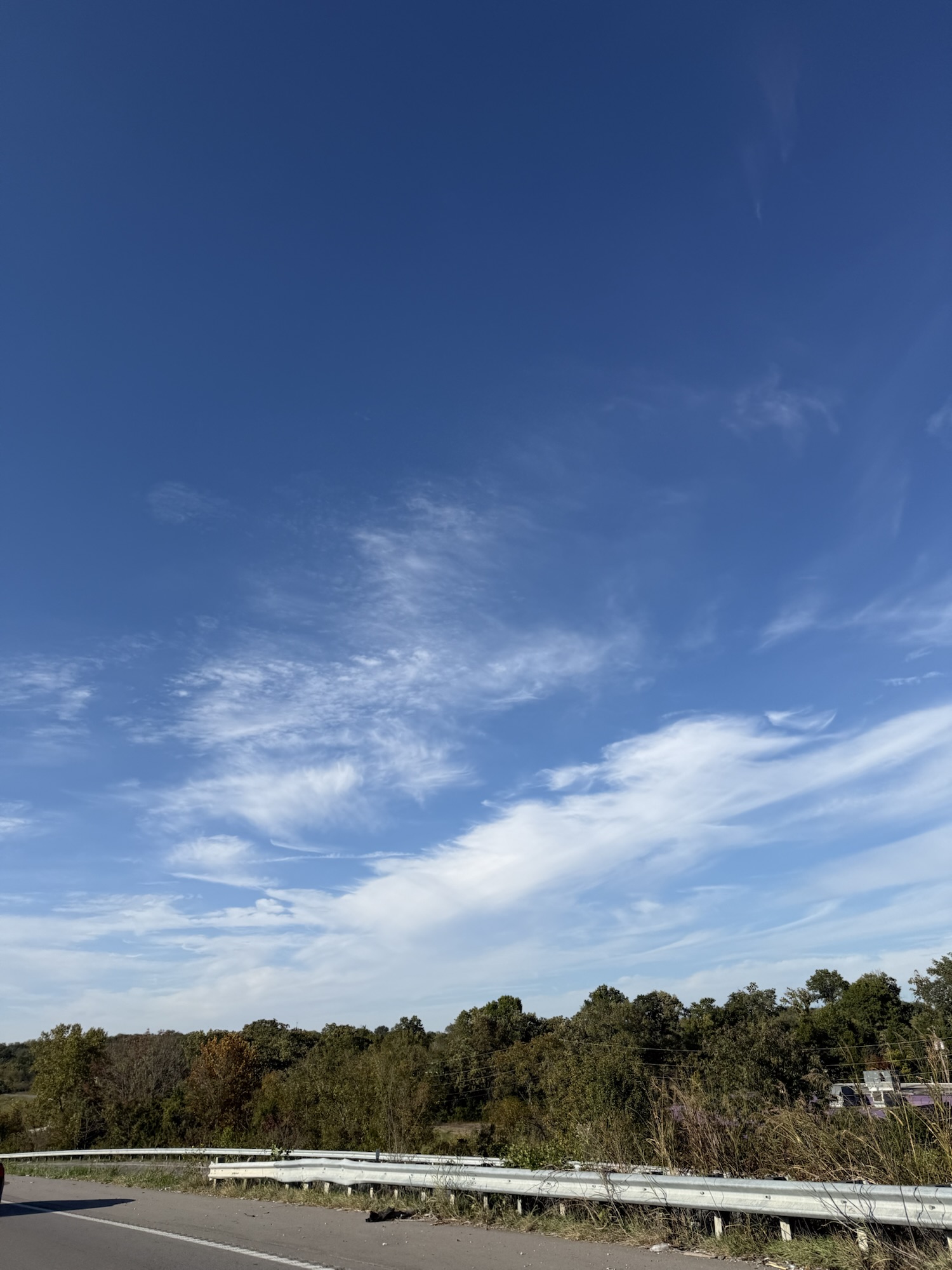 Closer view of sweeping thin white clouds with fine featherlike textures.