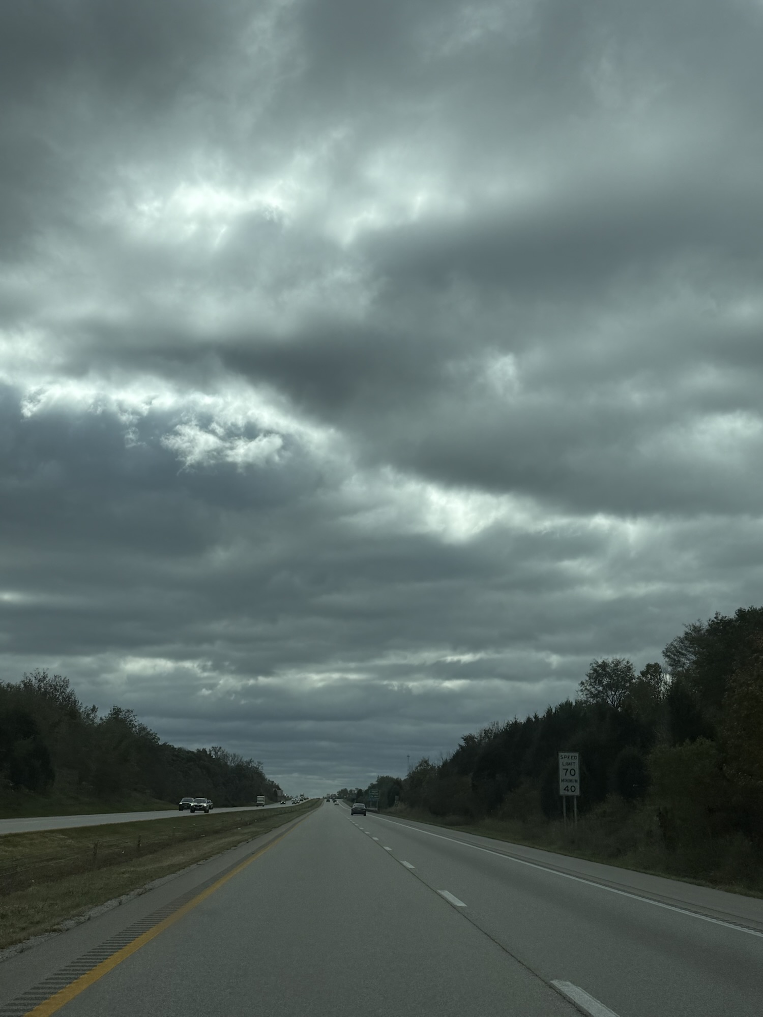 Dark textured cloud layers and filtered light over highway